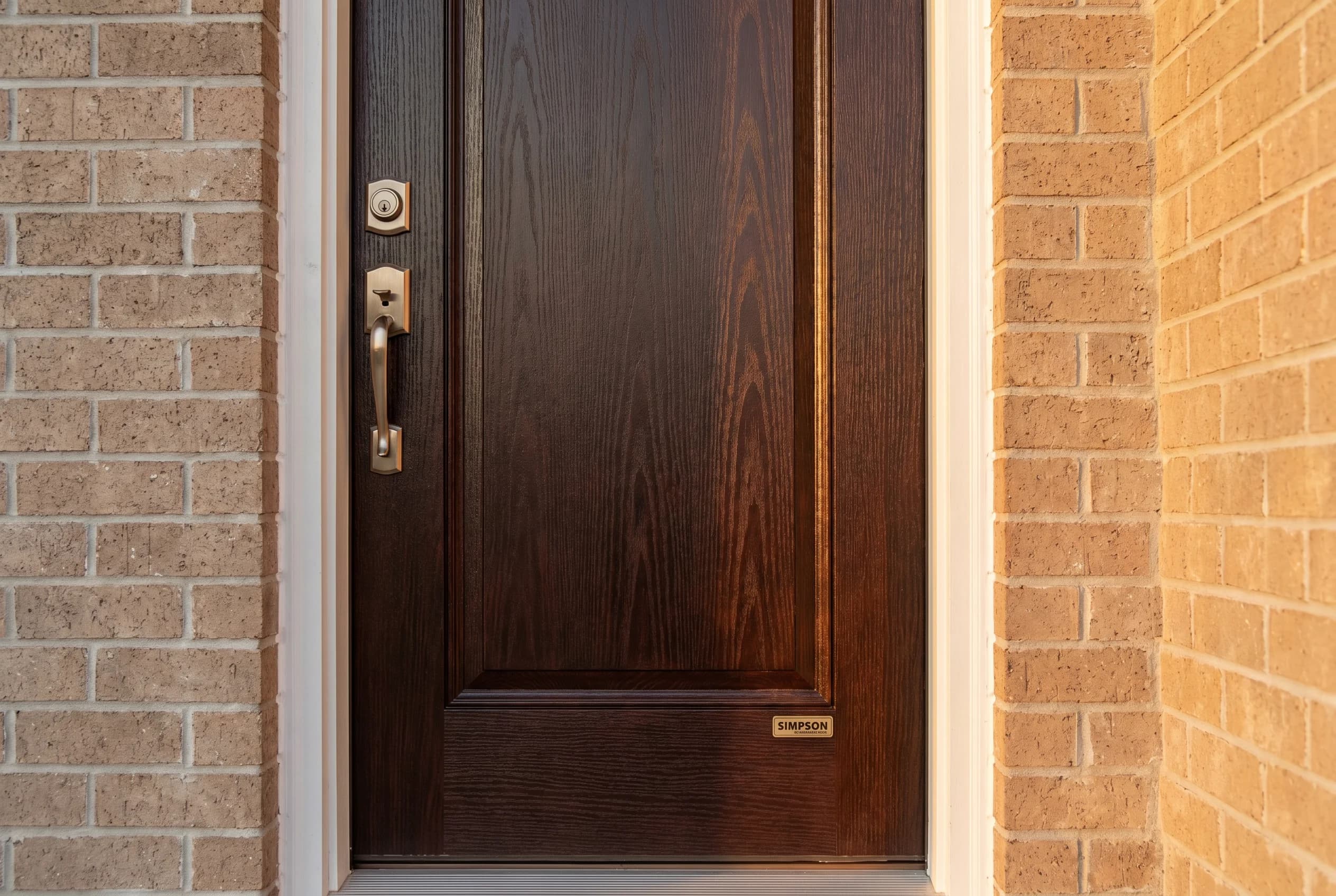 Brand-new Simpson Mastergrain fiberglass entry door with realistic deep wood-grain emboss in stained mahogany finish, brushed bronze hardware
